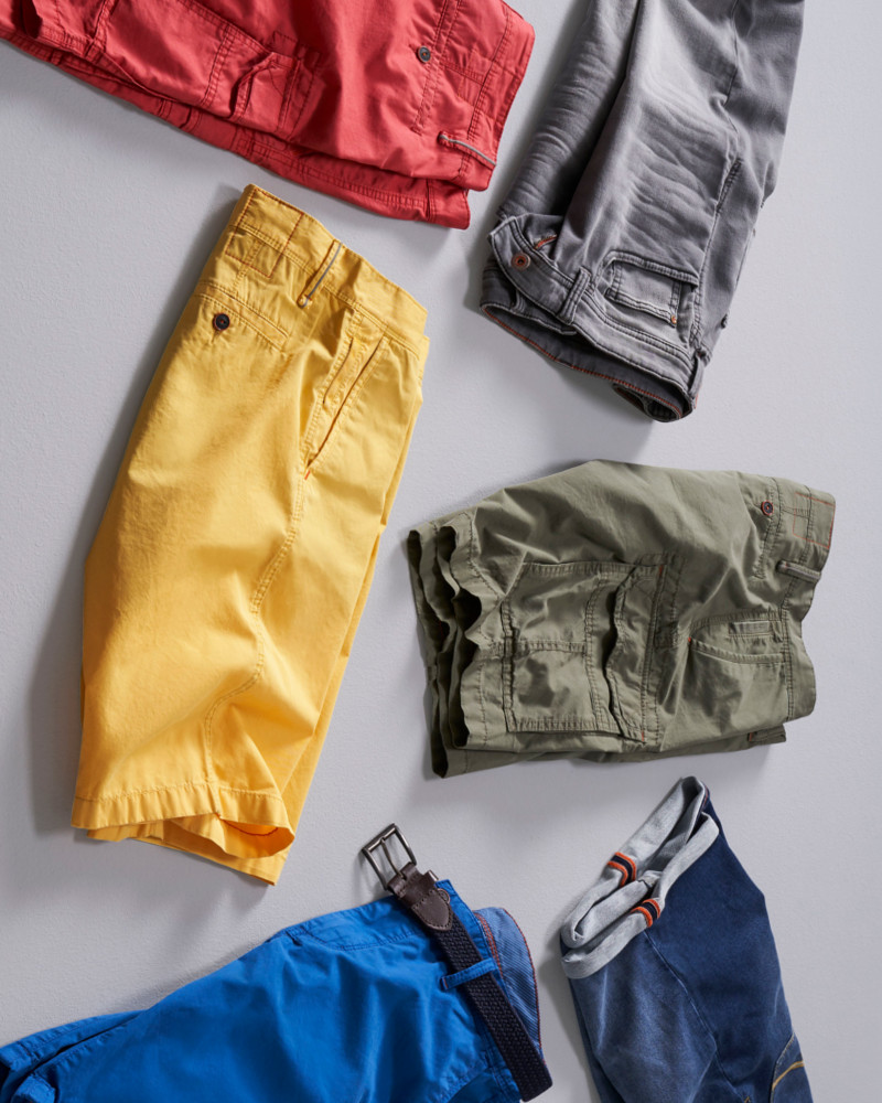 Mehrere bunte Bermuda Shorts auf dem Boden